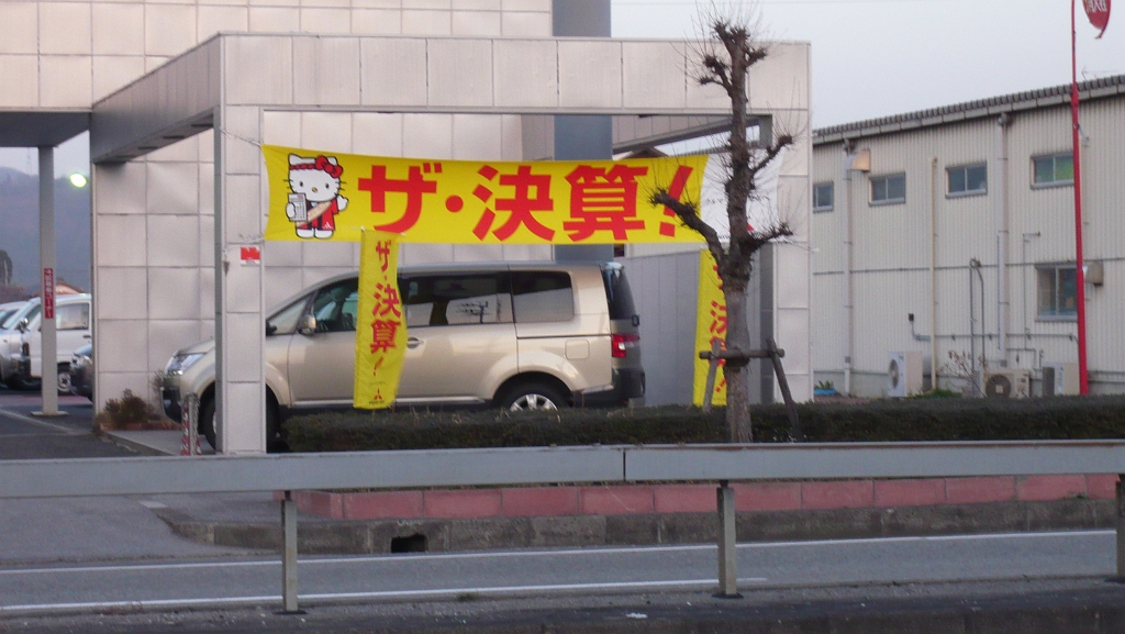 p1000014.jpg - And then I took my new camera out for a walk around the area I lived in, where I noticed Hello Kitty selling cars.  Also note what many Japanese towns do to their poor trees.