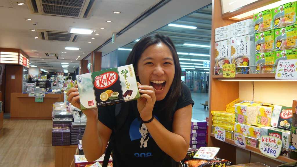 p1020537.jpg - We found Kyushu Limited Edition Kit Kats!  Myra collects Japan's crazy Kit Kat flavors, hence her beaming face.  These were yuzu-kosho (a citrus fruit and a kind of pepper).  Not bad, actually.