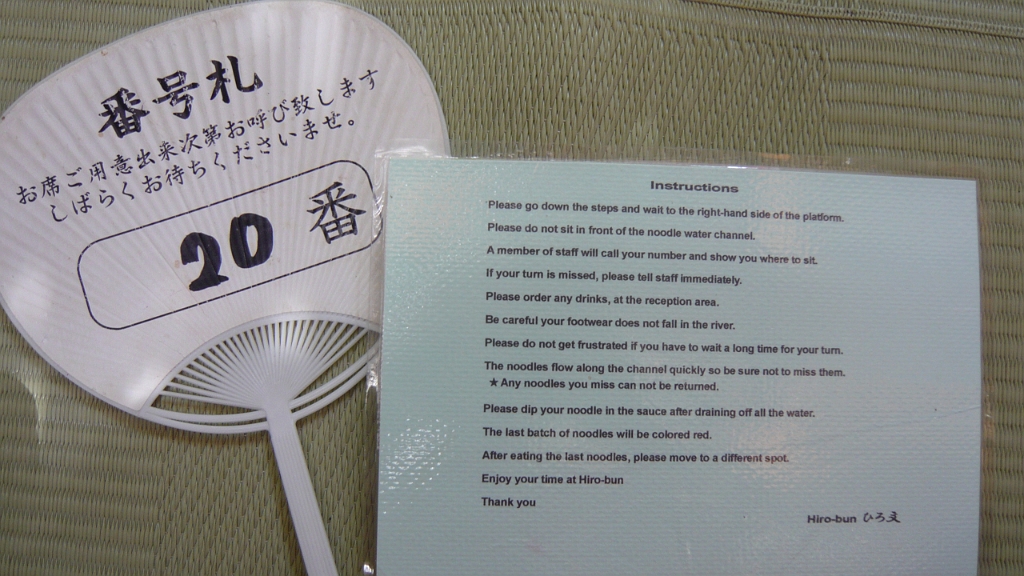 P1020824.JPG - Here are some instructions, and an uchiwa fan that had our number in line.