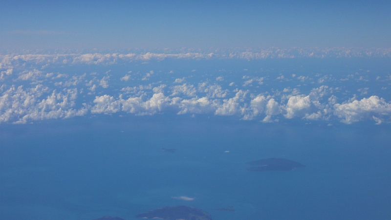 p1010693.jpg - A few hours later, we're over the Coral Sea.  I'm thrilled to see these islands, any of which could be where Azilie lives. :D  (That's my character in my current novel project, for those out of the loop.)