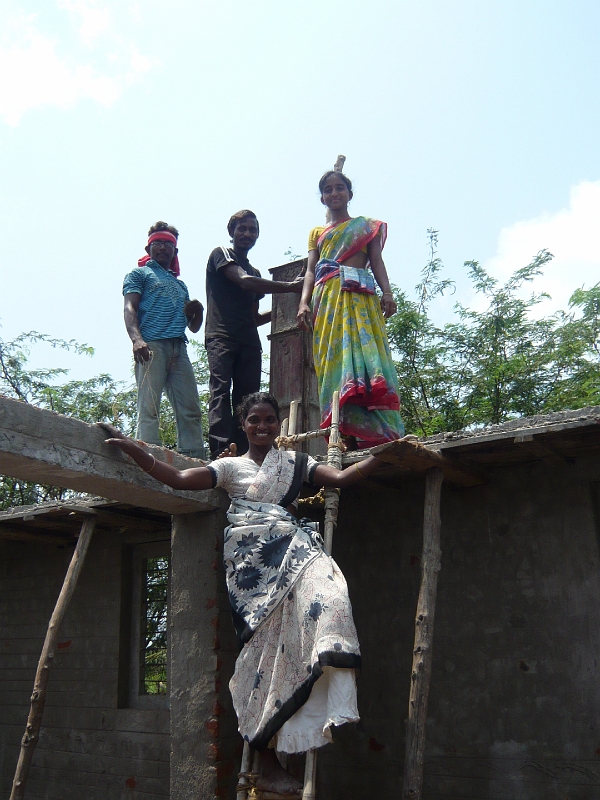 p1020148.jpg - We made an assembly line to hand trays of cement up to these guys for their roof.